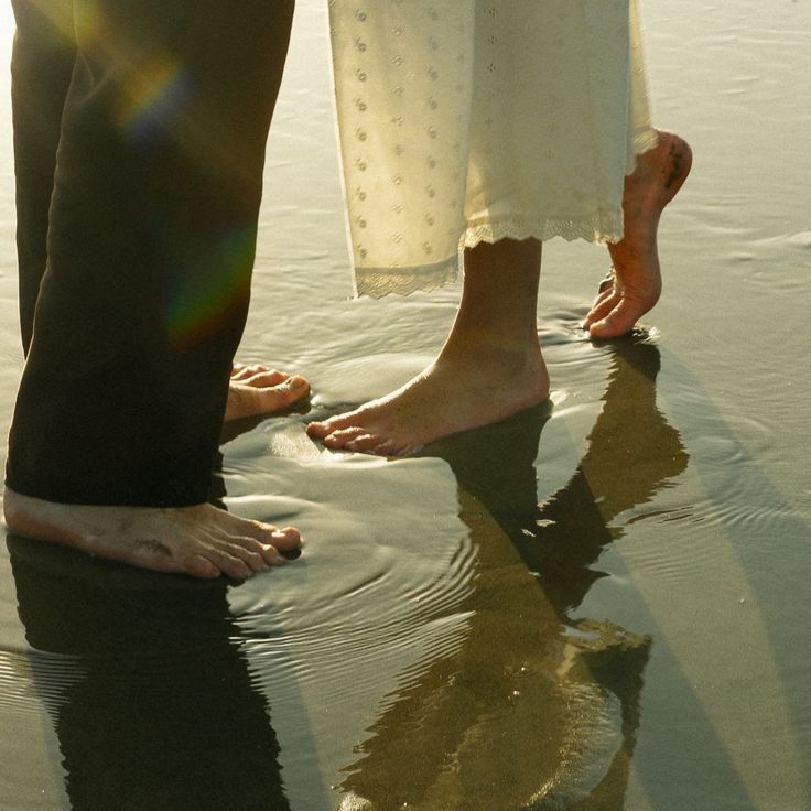 两个人赤脚站在浅浅的海水里