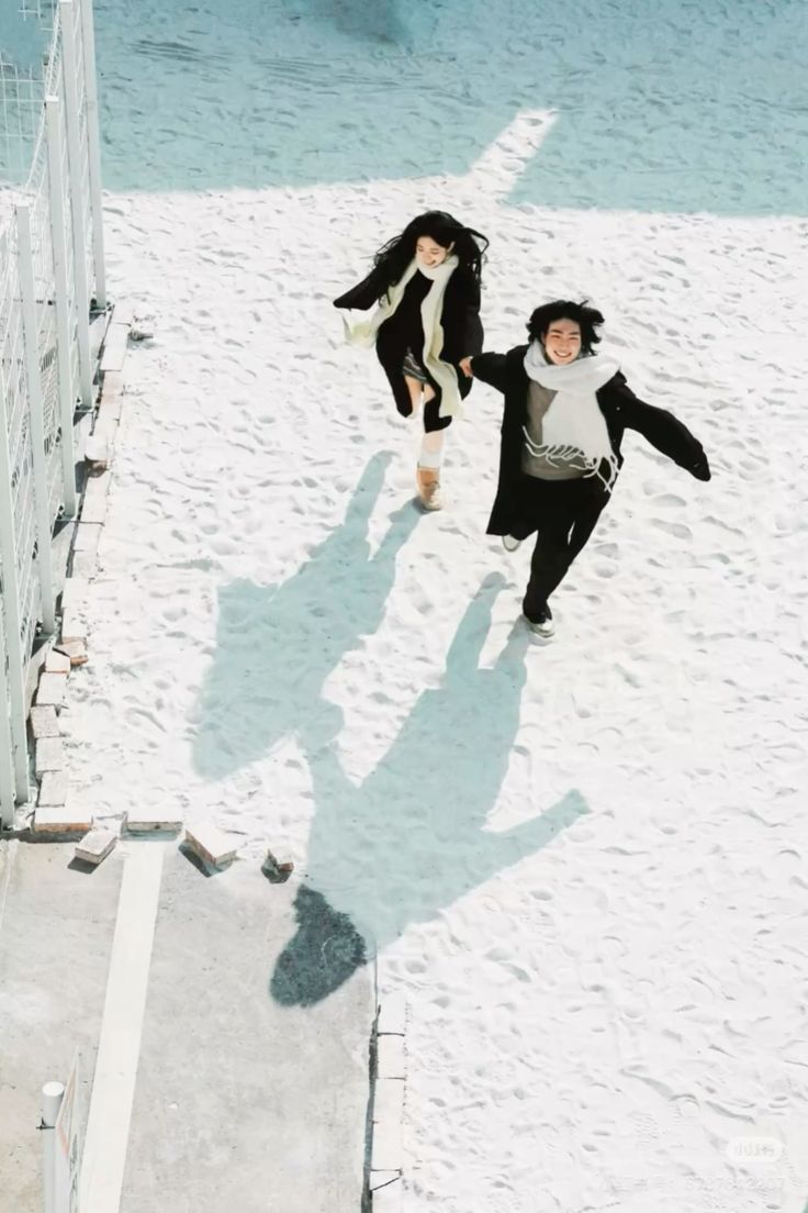 雪地里牵着手向前奔跑的两个人